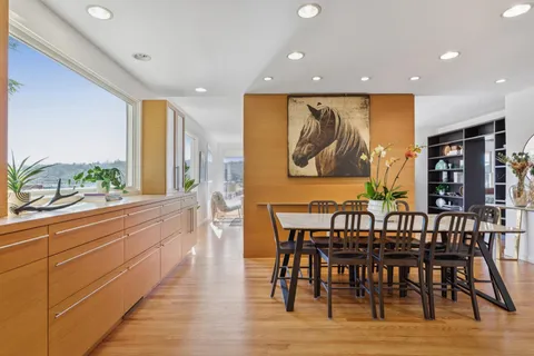 a view of a a dining room with furniture window and wooden floor