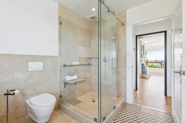 a bathroom with a granite countertop toilet and a shower