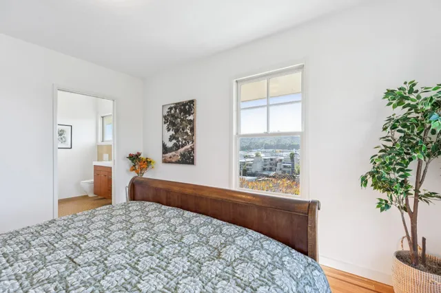 a bedroom with a bed and a potted plant