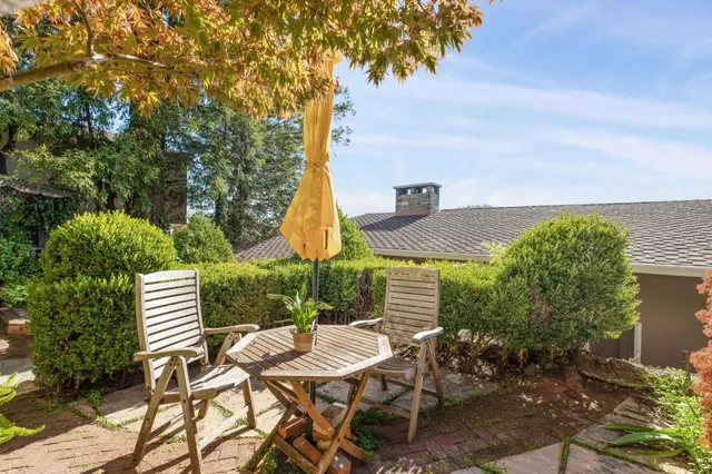 a view of a patio with table and chairs and potted plants