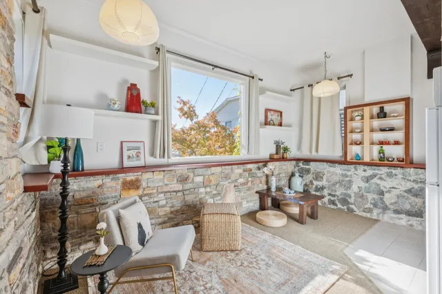 a living room with furniture and a painting on the wall