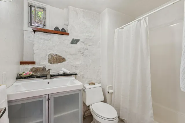 a bathroom with a sink a toilet and a mirror