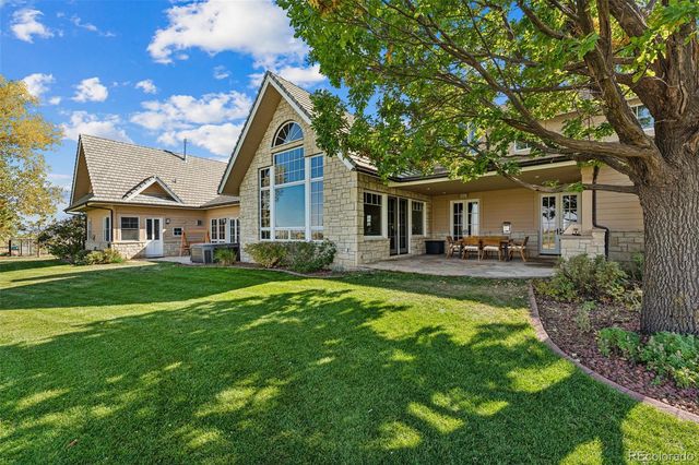 a view of house with a big yard and large trees