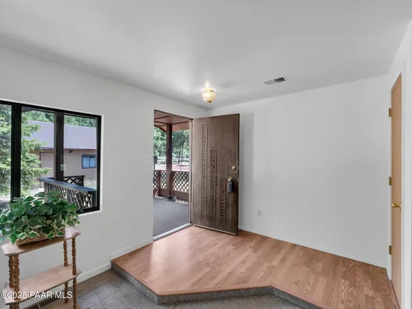 an empty room with potted plants and wooden floor