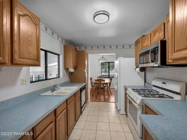 a kitchen with stainless steel appliances granite countertop a stove a sink dishwasher and cabinets with wooden floor