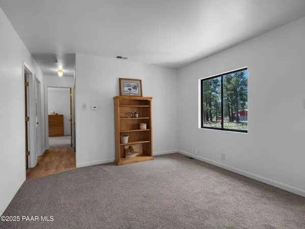 an empty room with a window and a bathroom