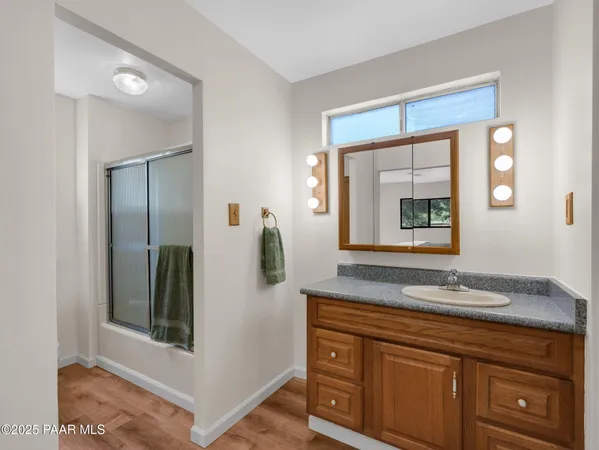 a bathroom with a granite countertop sink and mirror