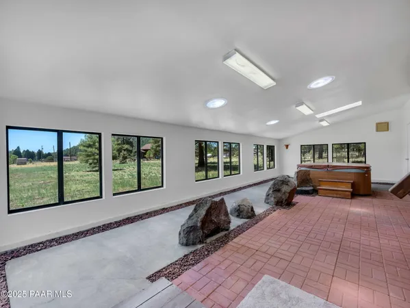 a living room with furniture tv and large windows