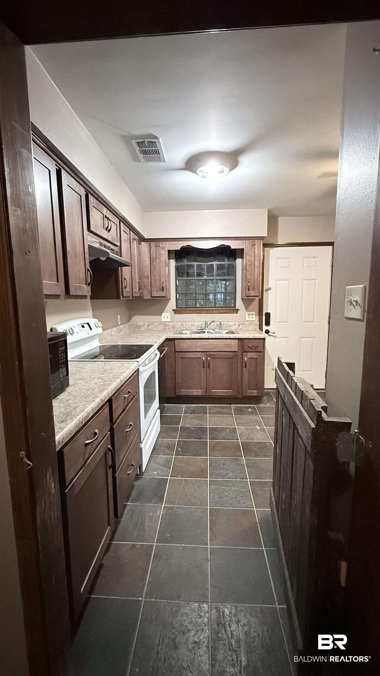 4131 Springdale Road Mobile, AL 36609 - Photo 20 of 28 Kitchen featuring electric stove, light countertops, black microwave, dark brown cabinets, and under cabinet range hood