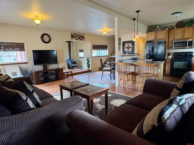 a living room with furniture and a flat screen tv with wooden floor