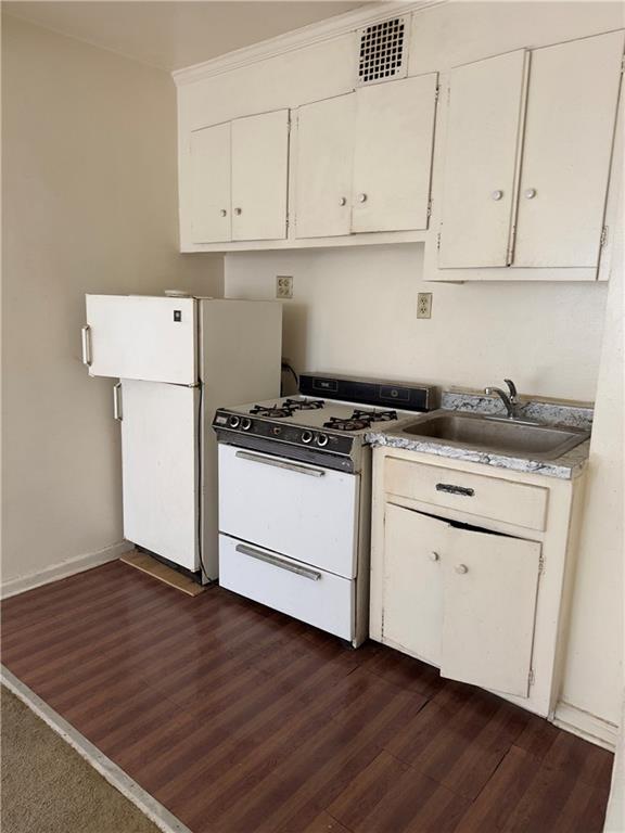 9430 Ridge Boulevard, Unit 1H Brooklyn, NY 11209 - Photo 3 of 7 a kitchen with granite countertop white cabinets and white appliances