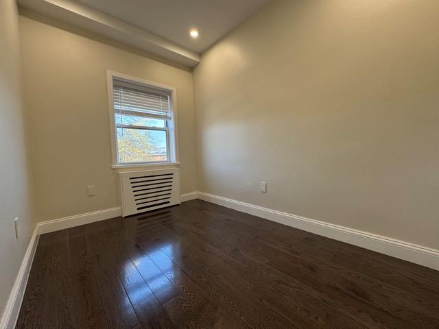 141-14 Booth Memorial Avenue Queens, NY 11355 - Photo 12 of 13 a view of an empty room with wooden floor and a window
