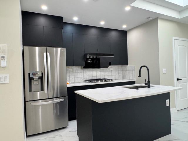 141-14 Booth Memorial Avenue Queens, NY 11355 - Photo 3 of 13 a kitchen with stainless steel appliances a refrigerator and a sink
