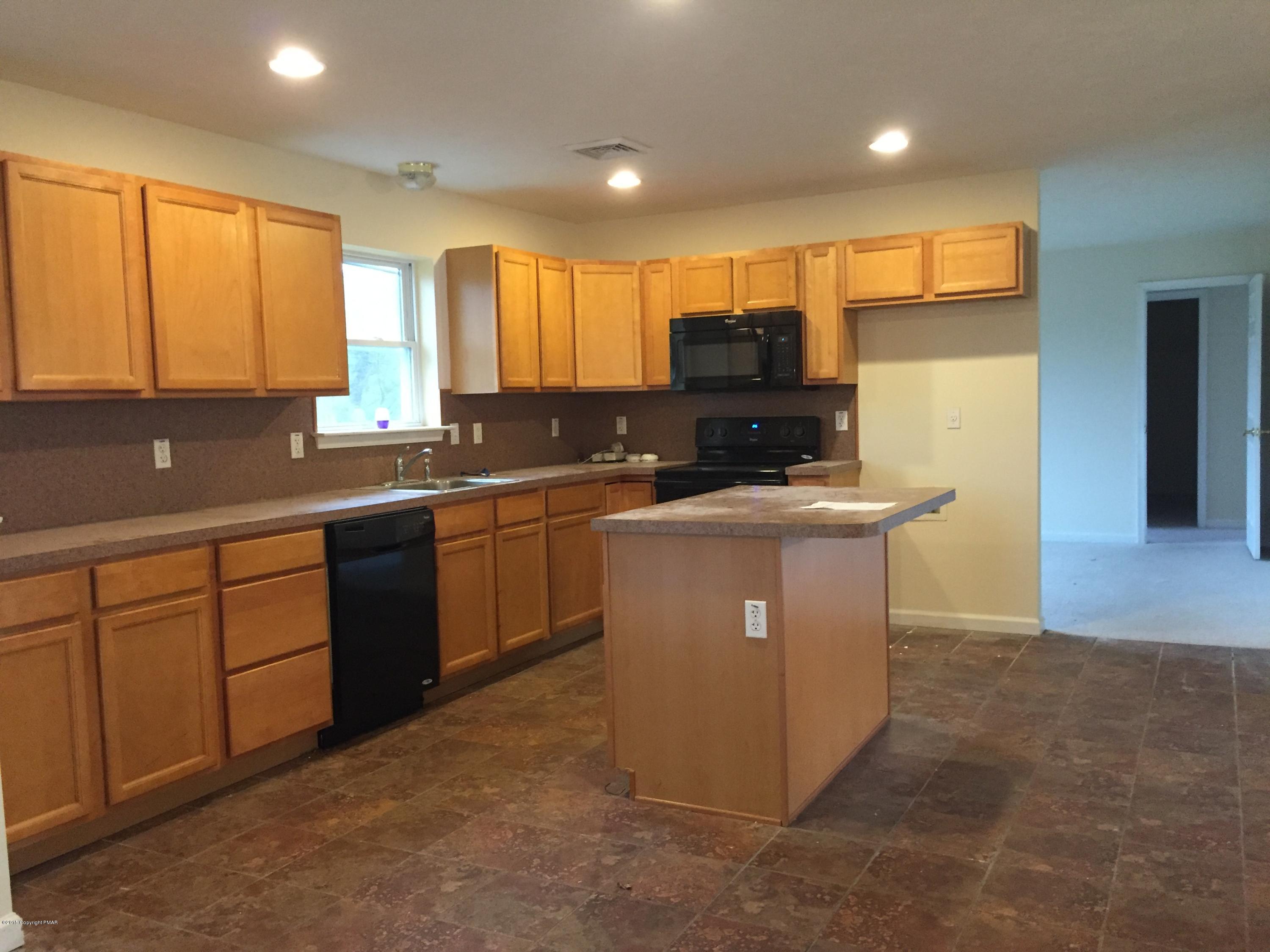 1653 Clover Road North Long Pond, PA 18334 - Photo 3 of 15 a kitchen with stainless steel appliances granite countertop a sink a stove a refrigerator cabinets and a window