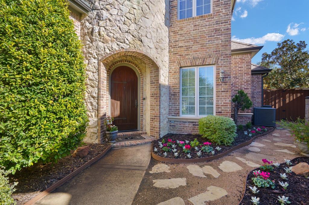 6724 Frankford Road Dallas, TX 75252 - Photo 5 of 40 a front view of a house with a flower garden