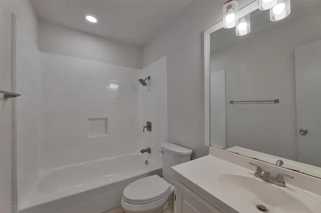 a bathroom with a sink toilet vanity and shower