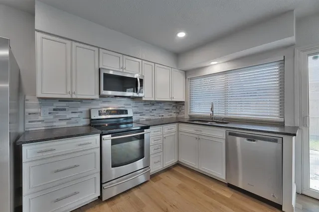 a kitchen with stainless steel appliances granite countertop a stove and a microwave