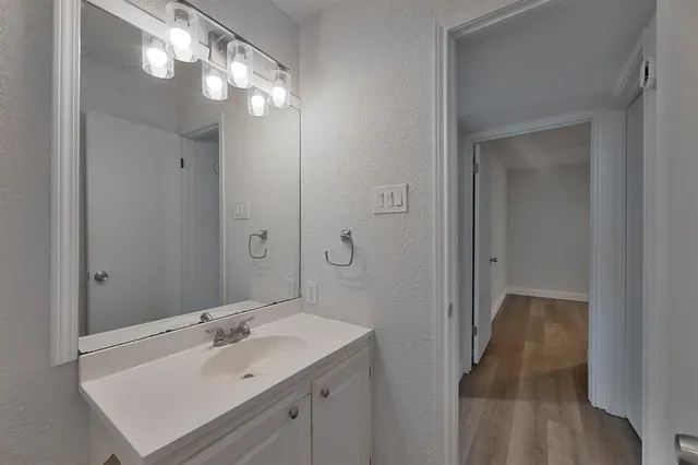 a bathroom with a sink a light fixture and a mirror