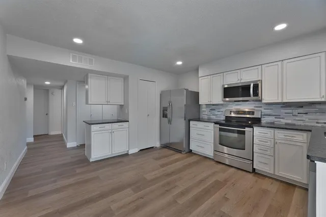 a kitchen with refrigerator a microwave and cabinets