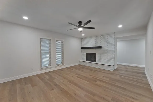 a view of an empty room with a fireplace and a window