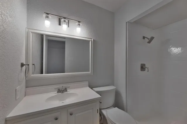 a bathroom with a sink toilet and mirror