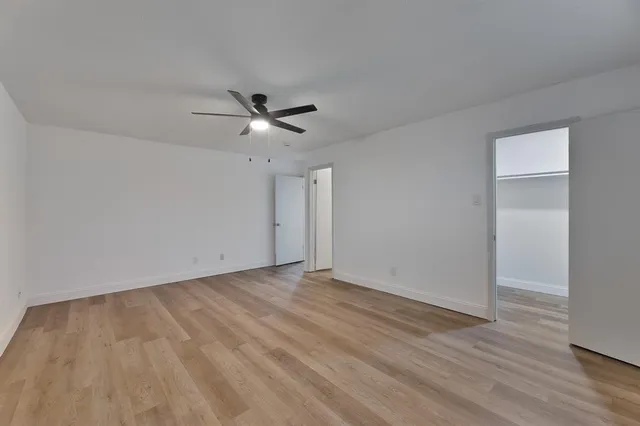 a view of an empty room with wooden floor