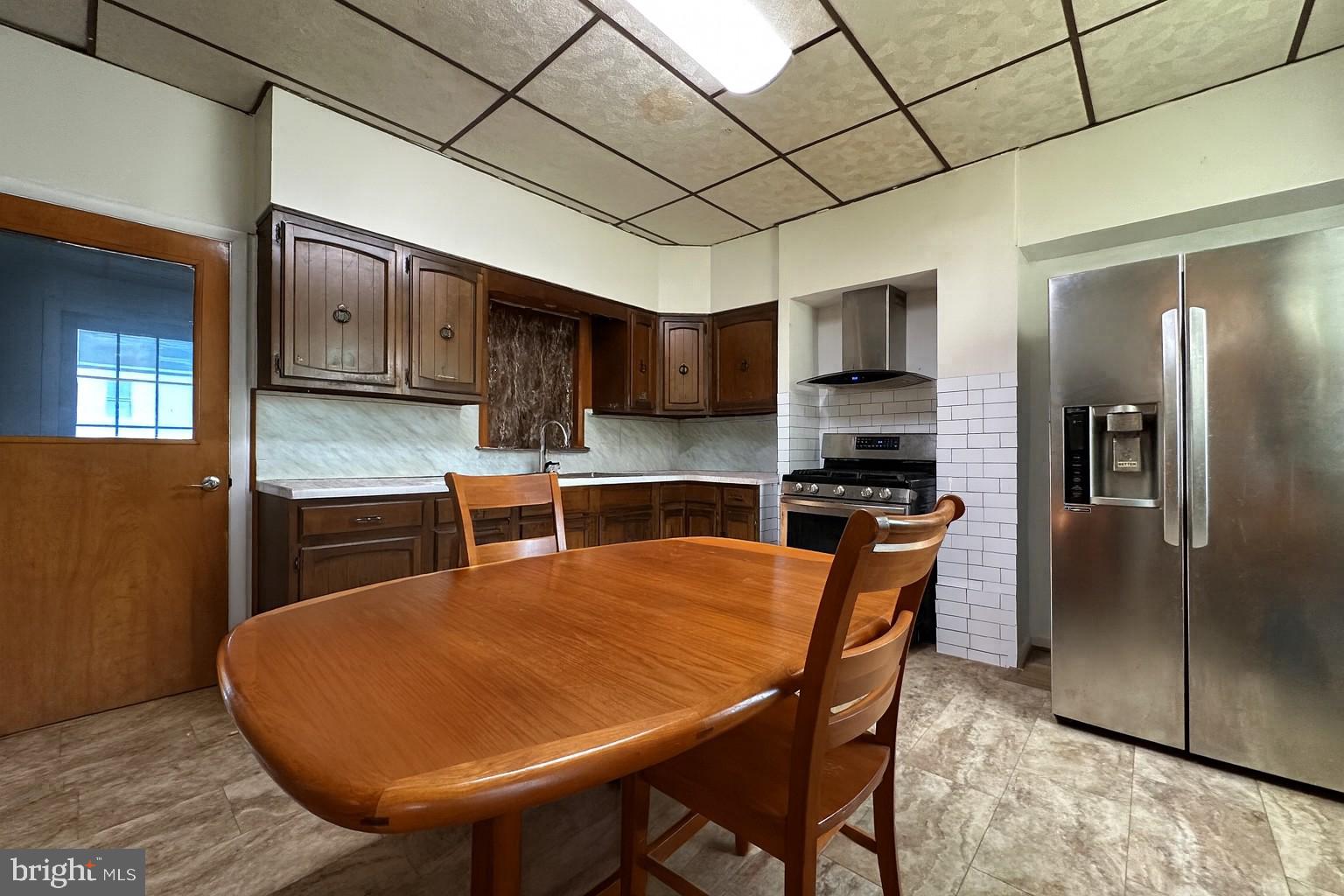 10128 Hummingbird Street Ellerslie, MD 21529 - Photo 6 of 21 a kitchen with stainless steel appliances granite countertop a sink refrigerator dining table and chairs