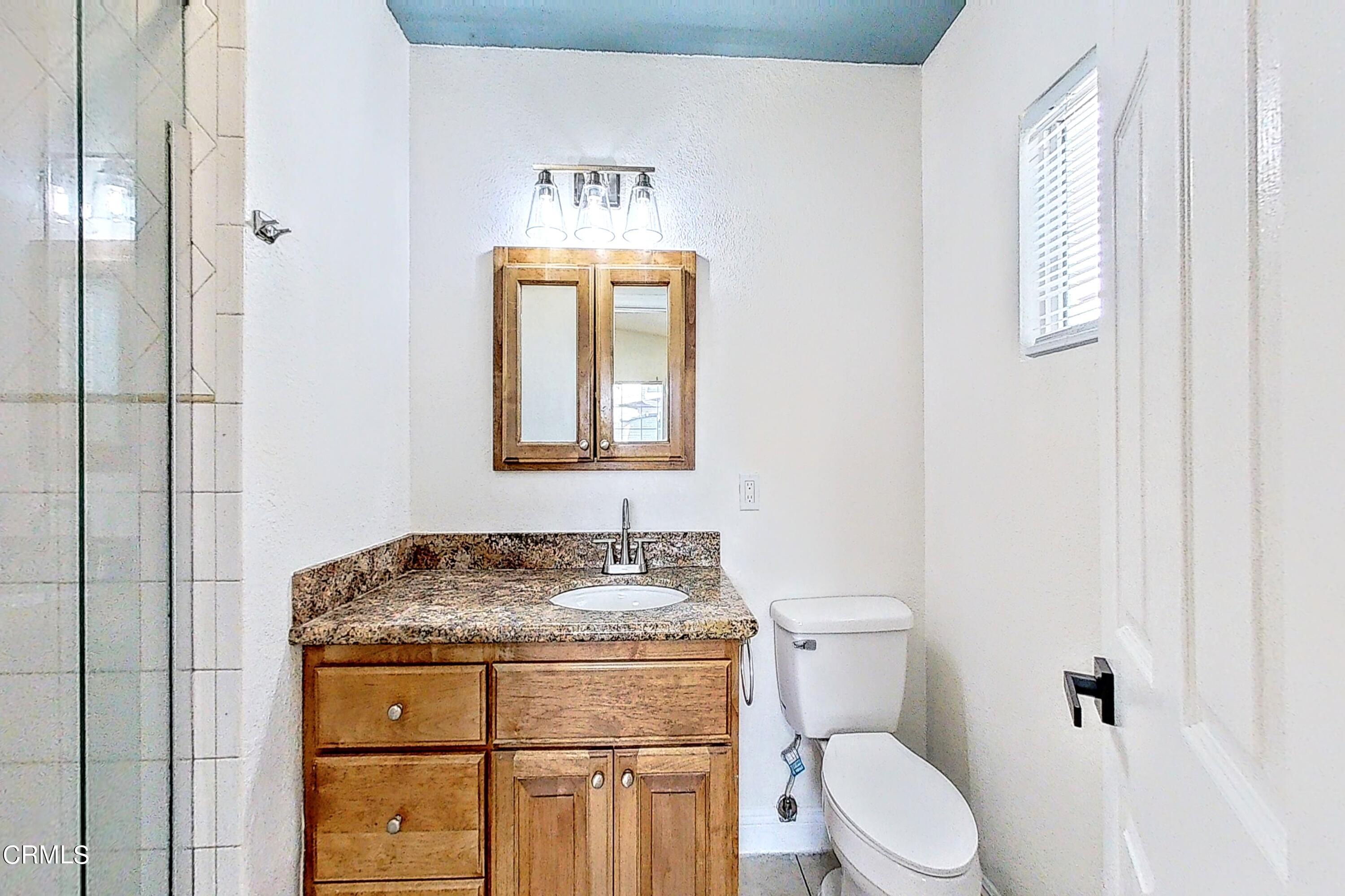 1830 Claremont Drive Oxnard, CA 93035 - Photo 24 of 36 a bathroom with a granite countertop toilet sink and mirror