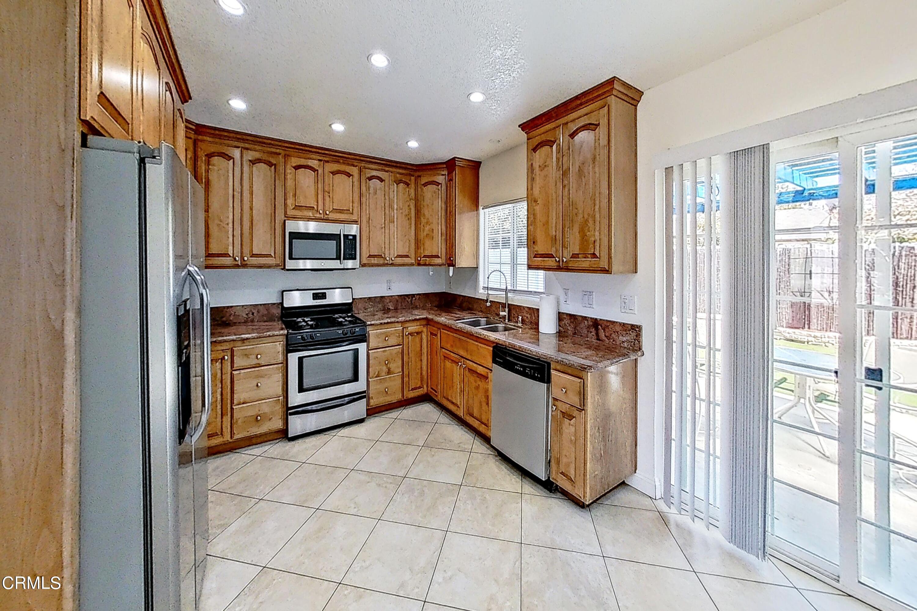 1830 Claremont Drive Oxnard, CA 93035 - Photo 9 of 36 a kitchen with stainless steel appliances granite countertop a stove a sink and a refrigerator