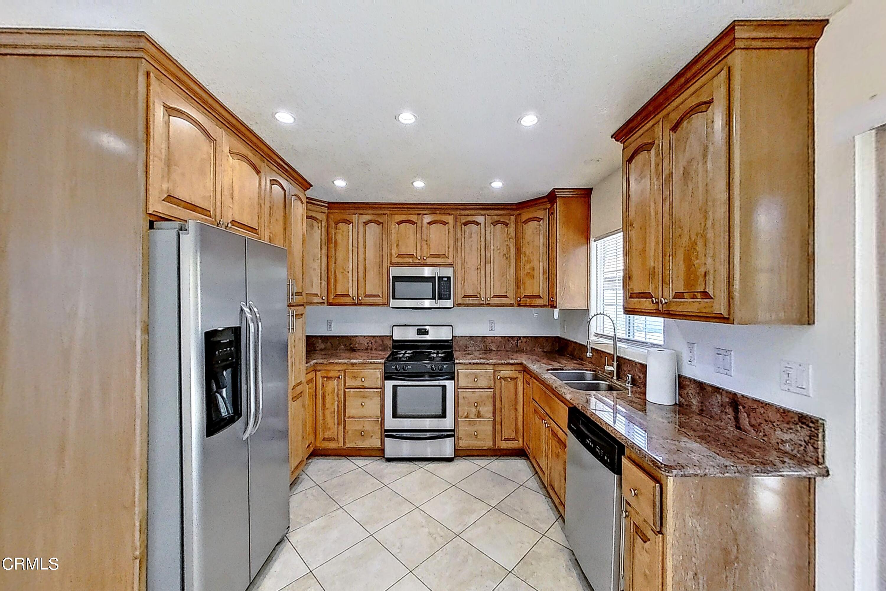 1830 Claremont Drive Oxnard, CA 93035 - Photo 10 of 36 a kitchen with stainless steel appliances granite countertop a stove a sink and a refrigerator