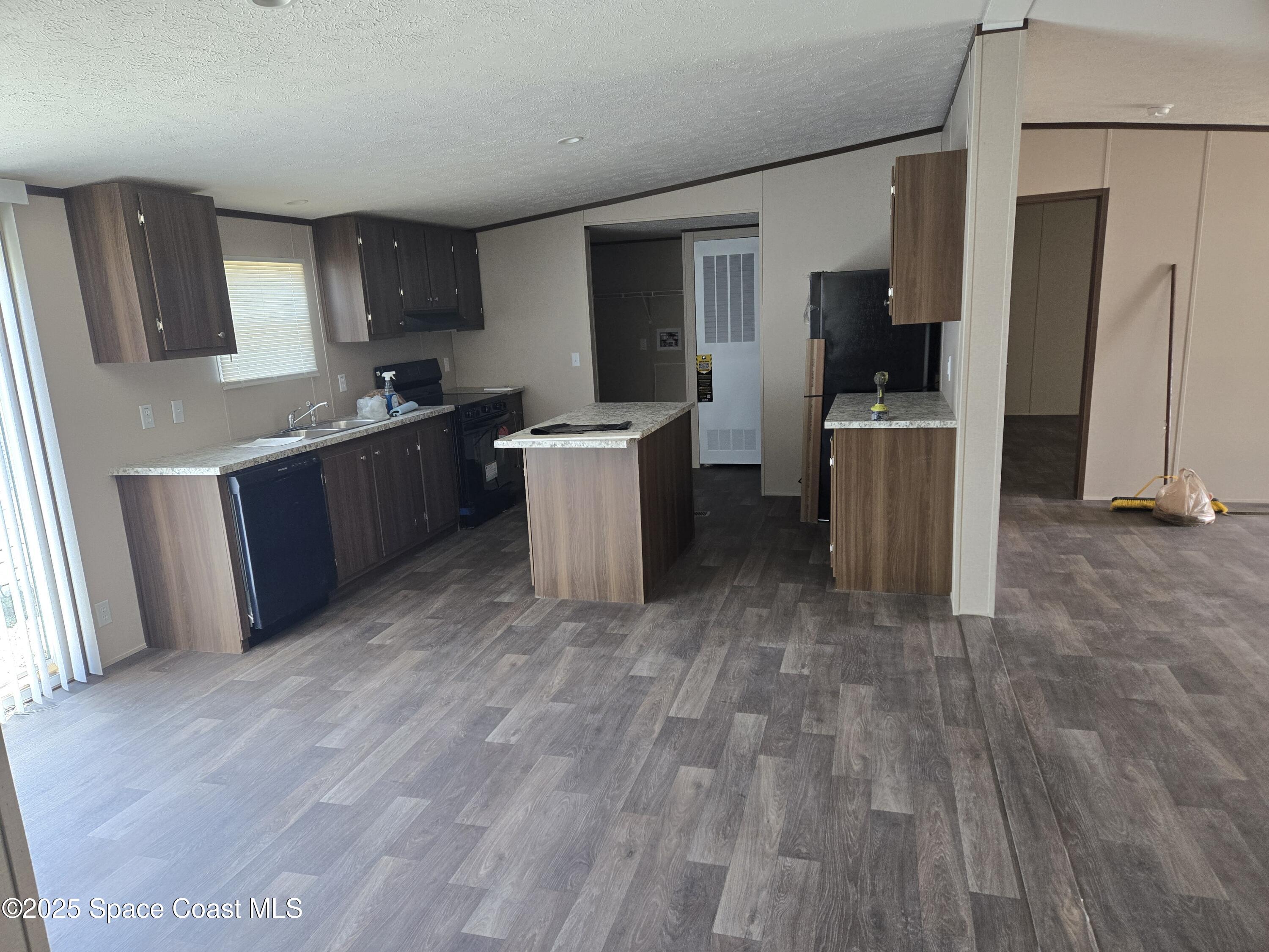 a kitchen with a wooden floor and a refrigerator