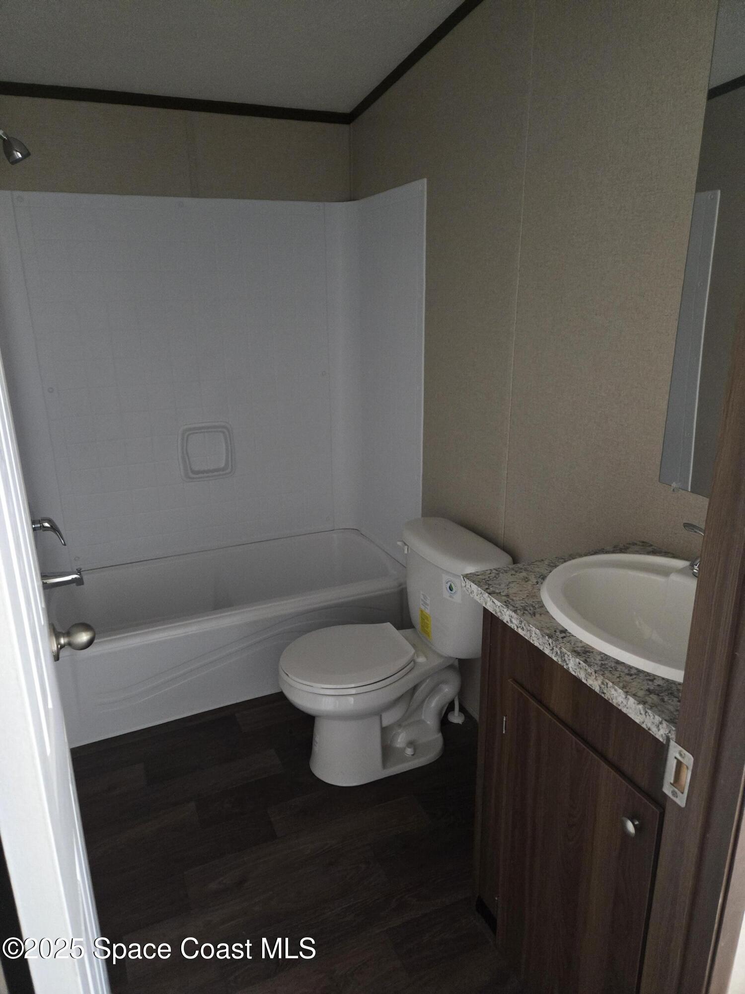 2534 Amberly Road Northeast Palm Bay, FL 32905 - Photo 4 of 5 a white toilet sitting next to a shower