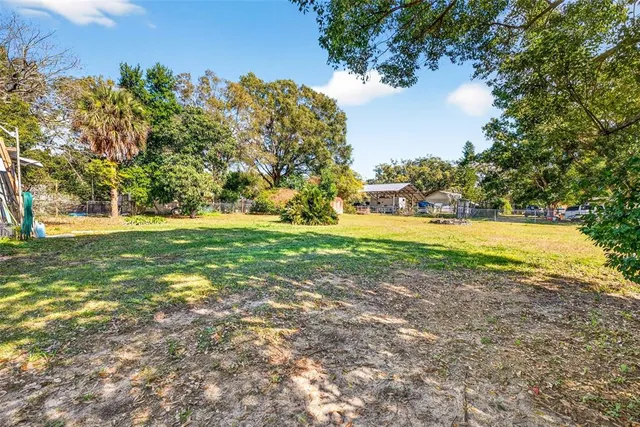 a view of a house with a big yard and large trees