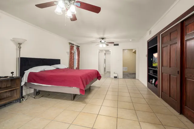 a spacious bedroom with a bed and a chandelier