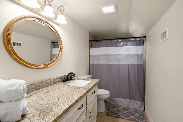 a bathroom with a granite countertop sink and a mirror