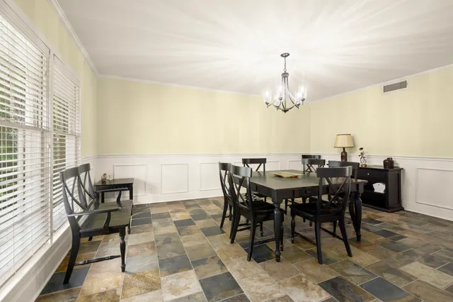 a view of a dining room with furniture and chandelier