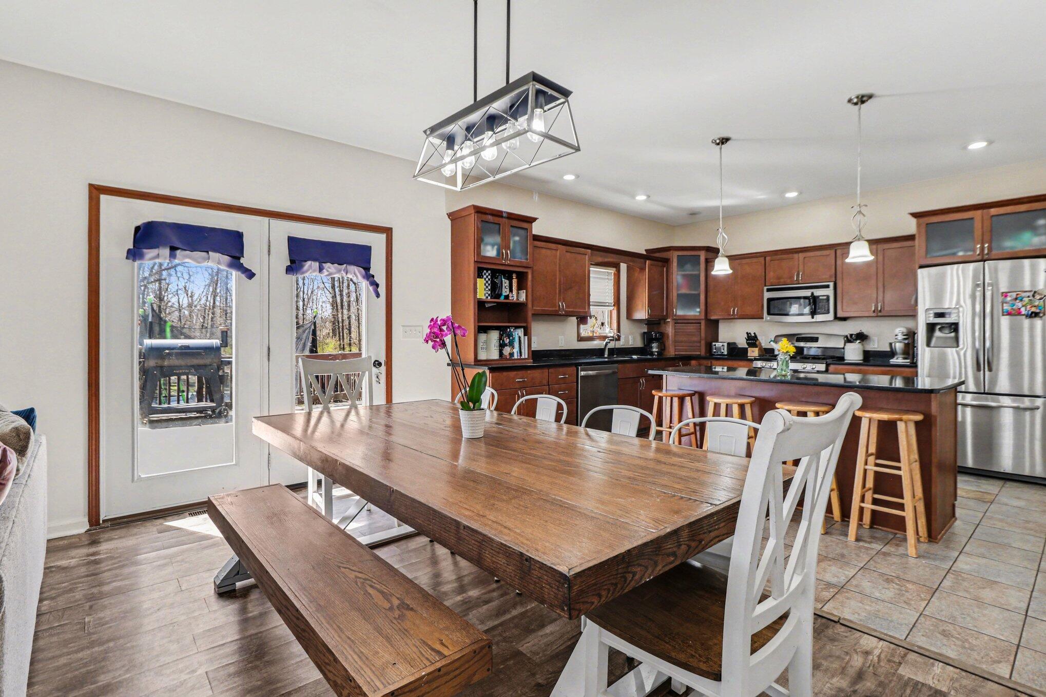 190 East Mekeland Road Chesterton, IN 46304 - Photo 9 of 29 a dining room with stainless steel appliances kitchen island granite countertop a table chairs and a refrigerator