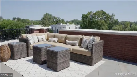 a roof deck with couches and potted plants