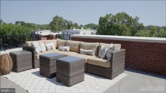 a roof deck with couches and potted plants