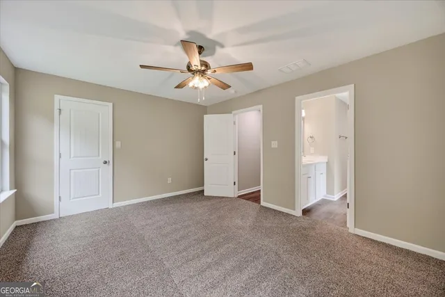 a view of an empty room with a ceiling fan