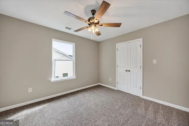 an empty room with fan and windows