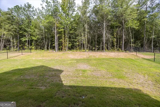 a view of a large yard with swimming pool and trees