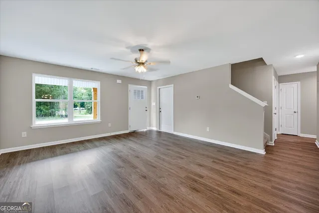 an empty room with wooden floor and window