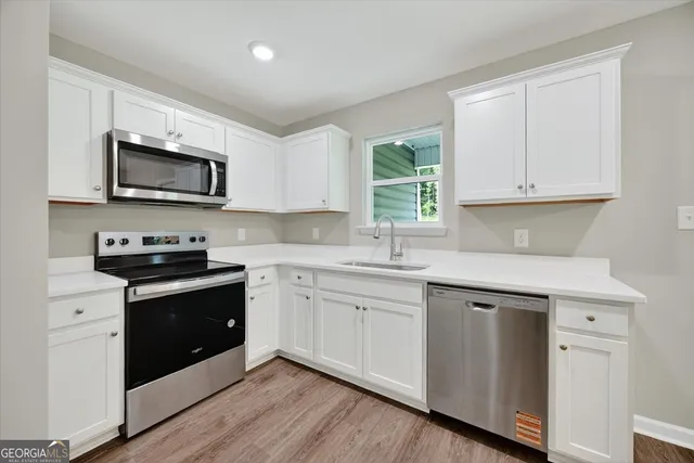 a kitchen with stainless steel appliances granite countertop a stove a sink and a microwave