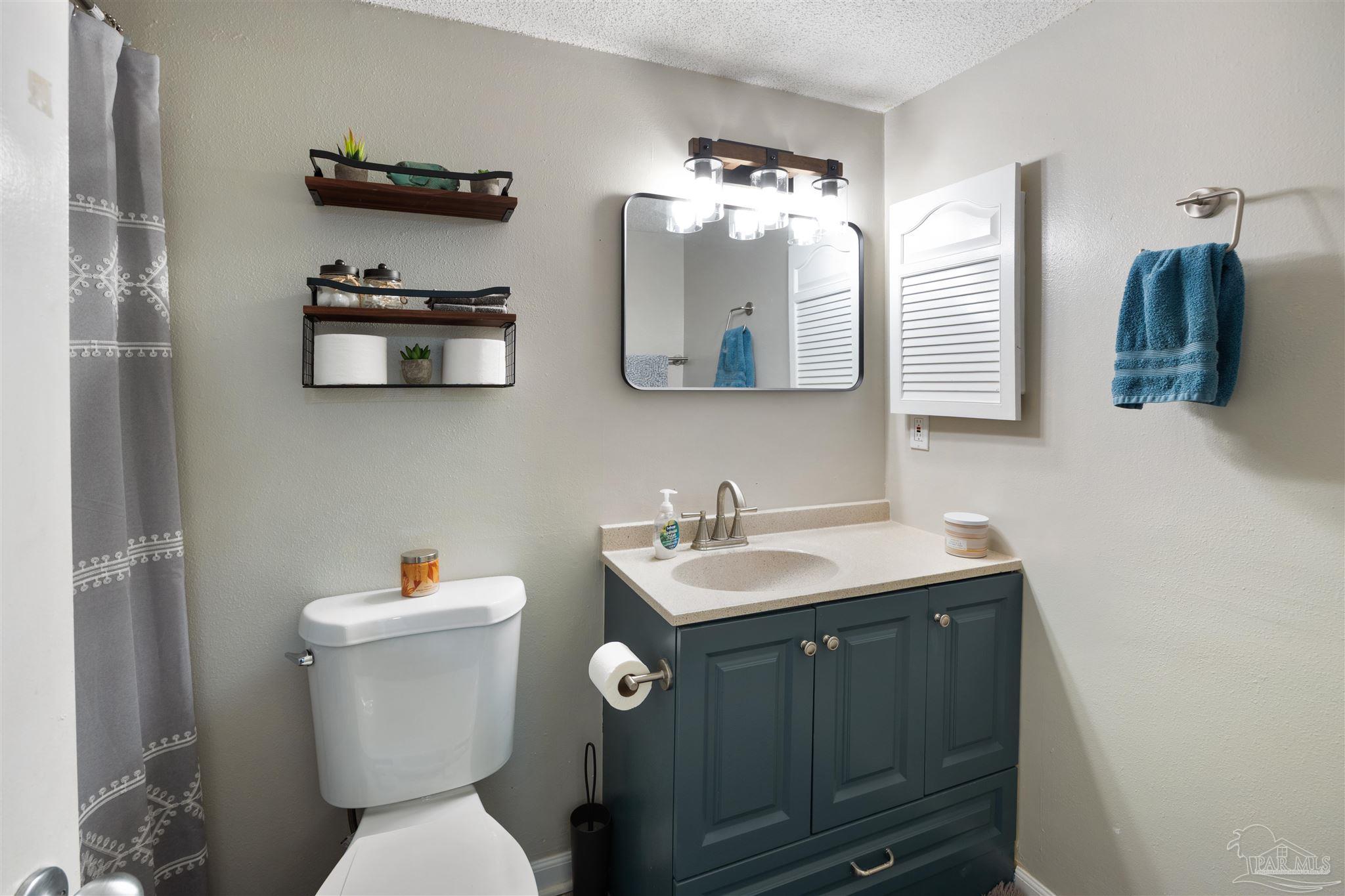 14100 River Road, Unit 122B Perdido Key, FL 32507 - Photo 27 of 46 a bathroom with a toilet sink and mirror