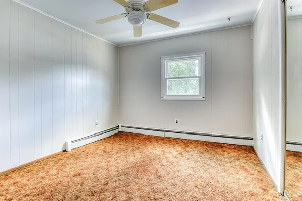 an empty room with a window and ceiling fan