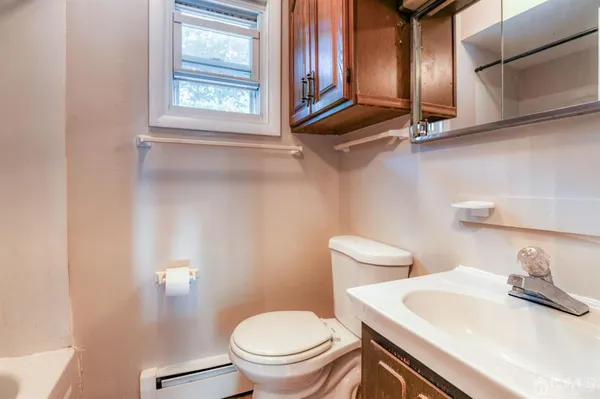 a bathroom with a granite countertop sink mirror vanity and toilet