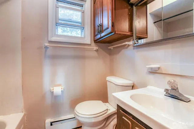 a bathroom with a granite countertop sink mirror vanity and toilet
