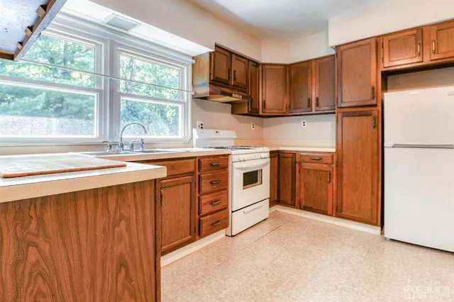 a kitchen with stainless steel appliances granite countertop a stove a sink dishwasher and a refrigerator