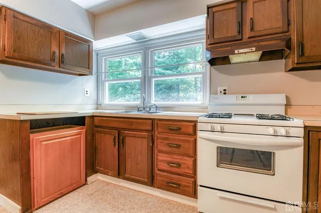 a kitchen with granite countertop a stove sink and cabinets